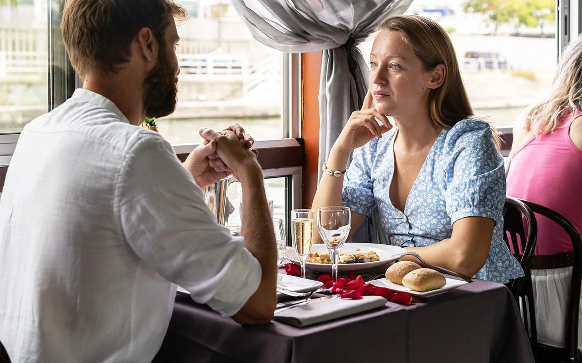 Couple dining beside the window of a La Marina cruise boat